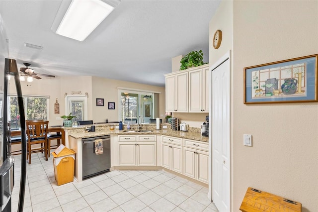 kitchen featuring sink, cream cabinets, light stone countertops, stainless steel dishwasher, and kitchen peninsula