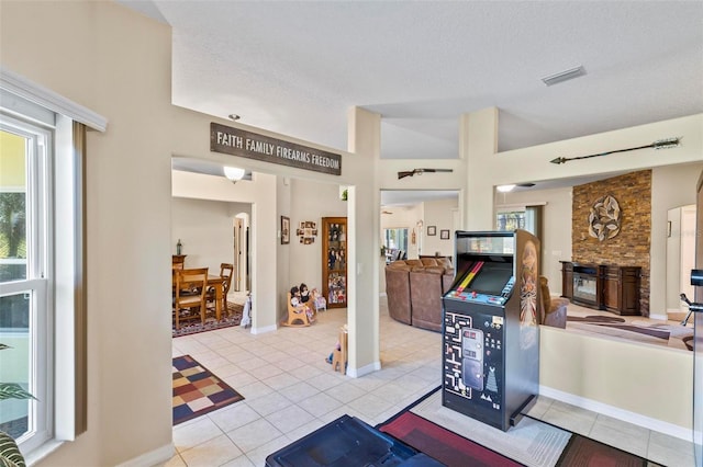 interior space featuring a fireplace, a textured ceiling, and light tile patterned floors