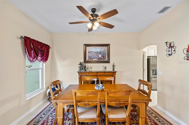 tiled dining area with ceiling fan