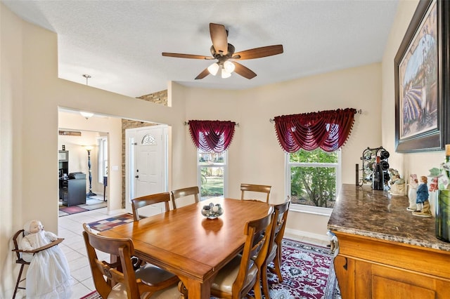 dining space with light tile patterned flooring, a healthy amount of sunlight, a textured ceiling, and ceiling fan