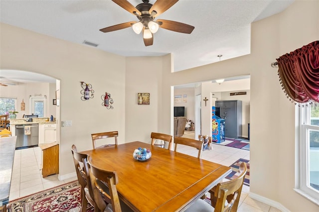 tiled dining room featuring a textured ceiling and ceiling fan