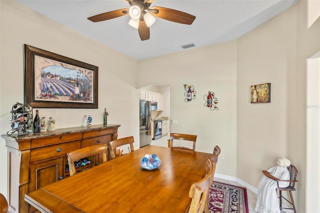 tiled dining space featuring ceiling fan