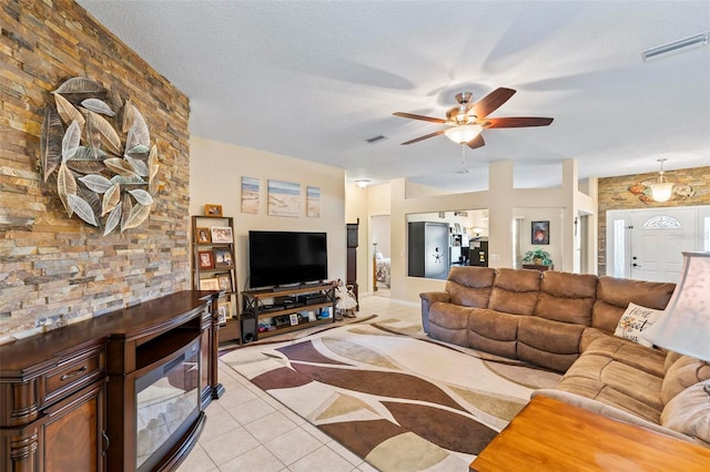 living room with ceiling fan, a textured ceiling, and light tile patterned floors