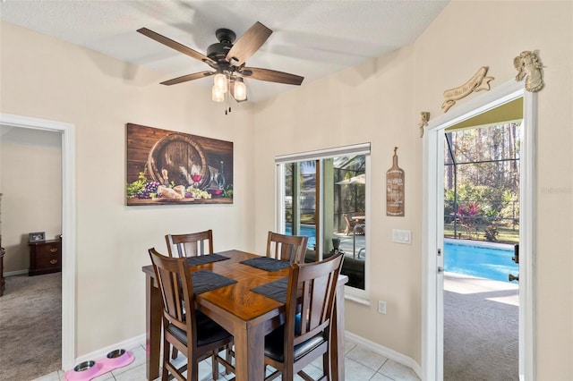 tiled dining area with a textured ceiling and ceiling fan