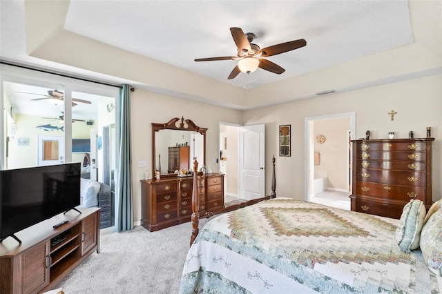 bedroom with ensuite bathroom, light carpet, and ceiling fan