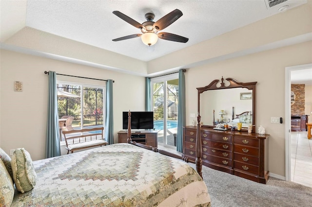 carpeted bedroom featuring ceiling fan, a raised ceiling, a textured ceiling, and access to outside