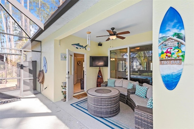 view of patio / terrace featuring ceiling fan, an outdoor hangout area, and glass enclosure