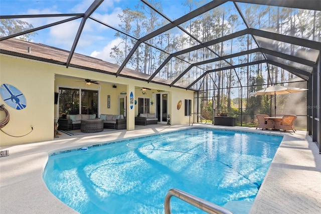 view of pool with a lanai, a patio area, outdoor lounge area, and ceiling fan