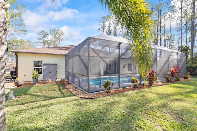 rear view of property featuring a yard and glass enclosure