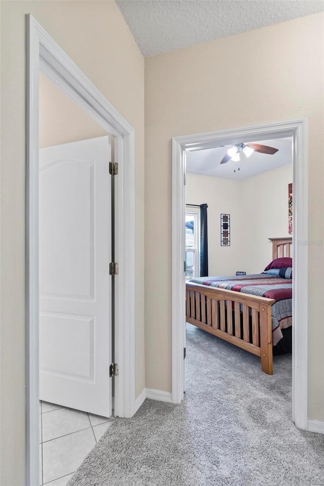 bedroom with light carpet, a textured ceiling, and ceiling fan