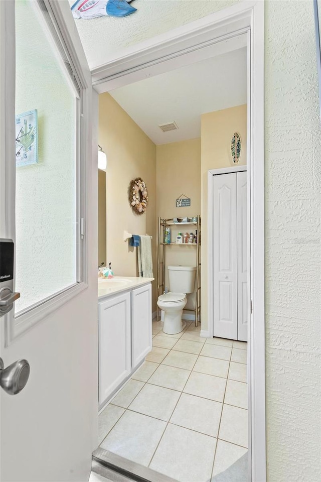 bathroom featuring tile patterned flooring, vanity, and toilet