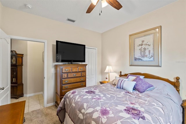 bedroom with light colored carpet, ceiling fan, and a closet