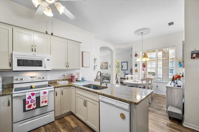 kitchen featuring white appliances, sink, decorative light fixtures, dark hardwood / wood-style flooring, and kitchen peninsula