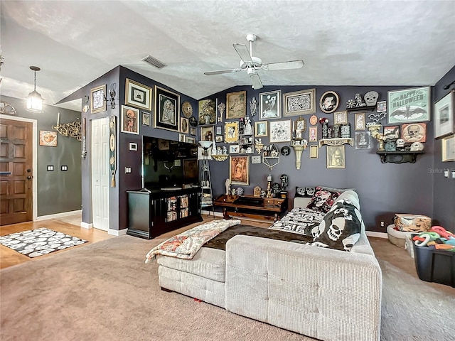 living room featuring a textured ceiling, carpet floors, ceiling fan, and lofted ceiling