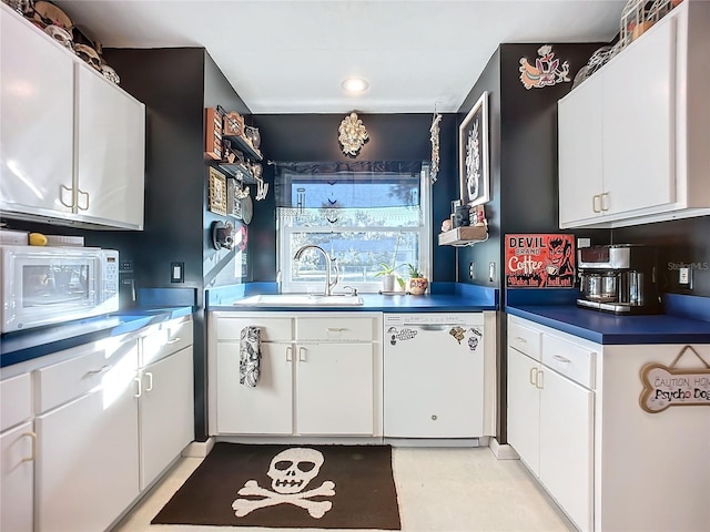 kitchen featuring white cabinets, white appliances, and sink