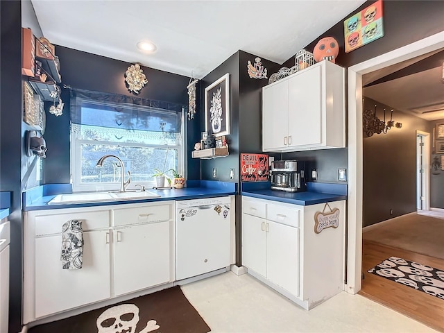 kitchen with dishwasher, white cabinetry, sink, and light hardwood / wood-style flooring