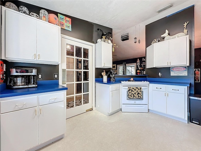 kitchen featuring white electric range oven and white cabinetry