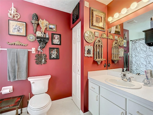 bathroom with tile patterned flooring, vanity, and toilet