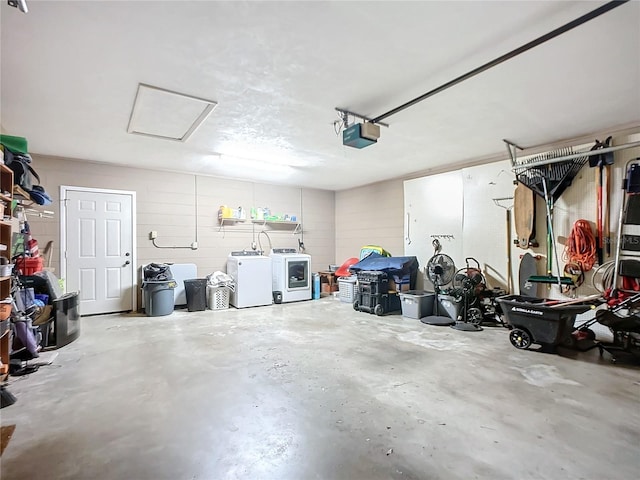 garage with washing machine and dryer and a garage door opener