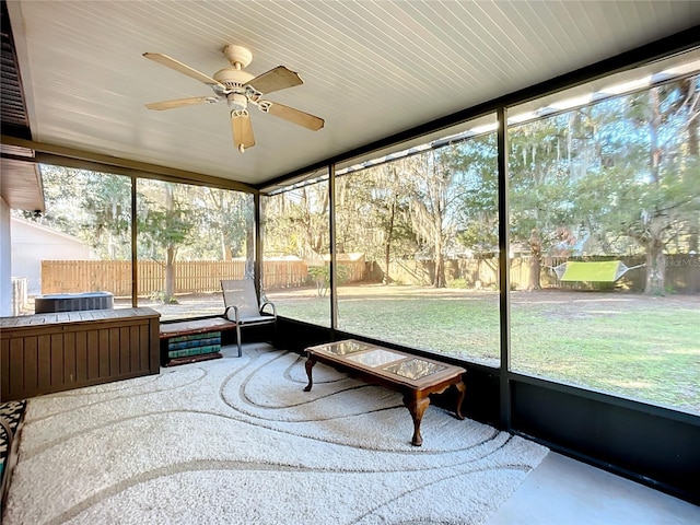 unfurnished sunroom featuring ceiling fan and plenty of natural light