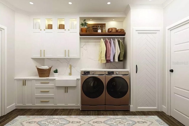 laundry room featuring sink, dark wood-type flooring, cabinets, independent washer and dryer, and ornamental molding