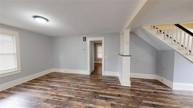 interior space featuring a textured ceiling, a wealth of natural light, and dark hardwood / wood-style floors