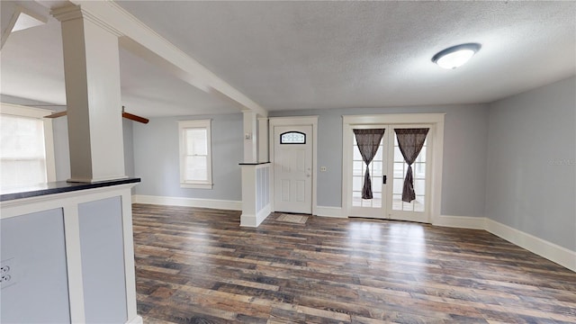 foyer with a textured ceiling, dark hardwood / wood-style flooring, and a wealth of natural light