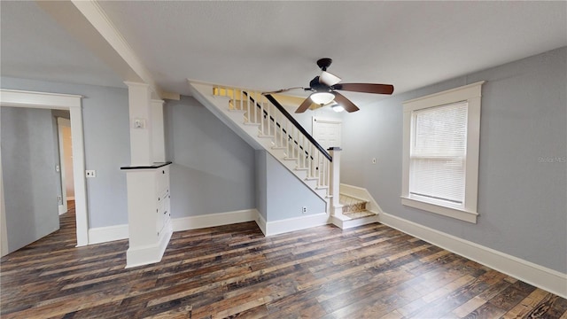 unfurnished living room with ceiling fan and dark wood-type flooring