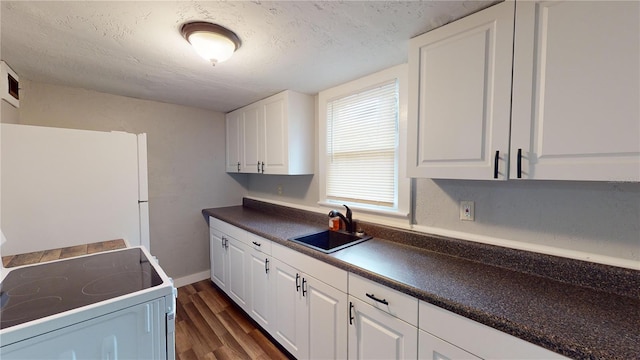 kitchen with white refrigerator, range, sink, and white cabinetry