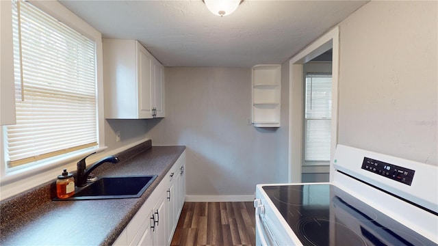 kitchen featuring white cabinetry, sink, dark wood-type flooring, and range