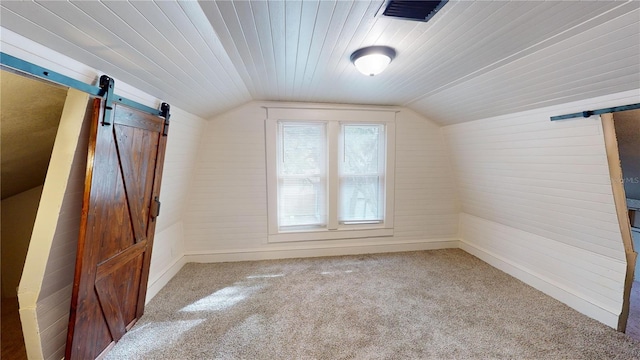 bonus room featuring carpet flooring, a barn door, and lofted ceiling