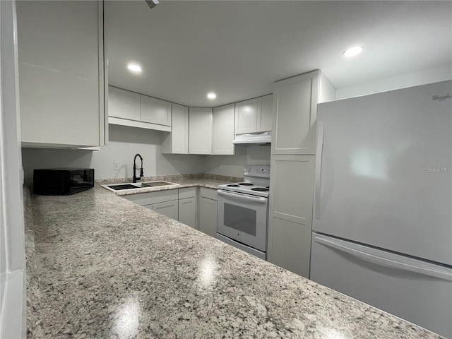 kitchen featuring white appliances, white cabinets, light stone countertops, and sink