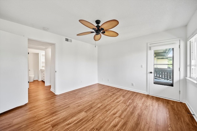 empty room featuring ceiling fan, light hardwood / wood-style flooring, and a textured ceiling