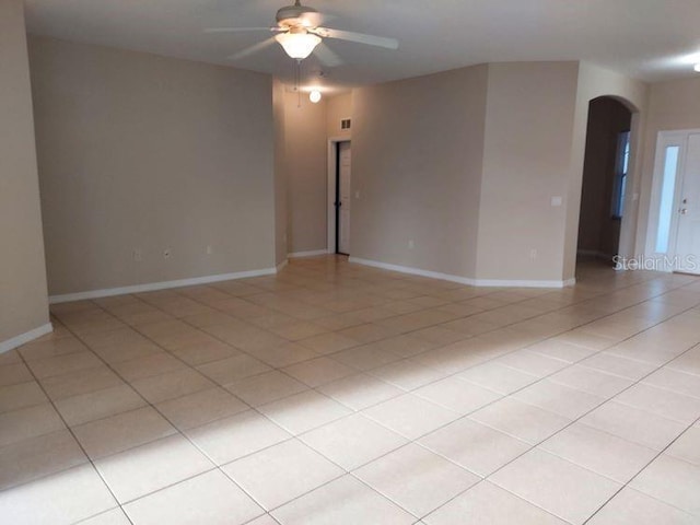 tiled spare room featuring ceiling fan