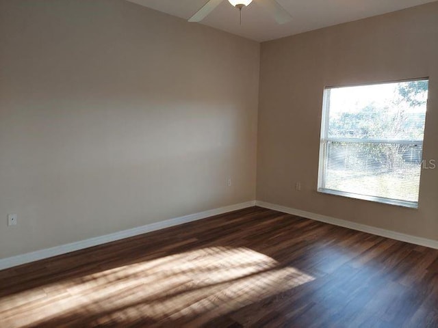 spare room with dark hardwood / wood-style flooring and ceiling fan