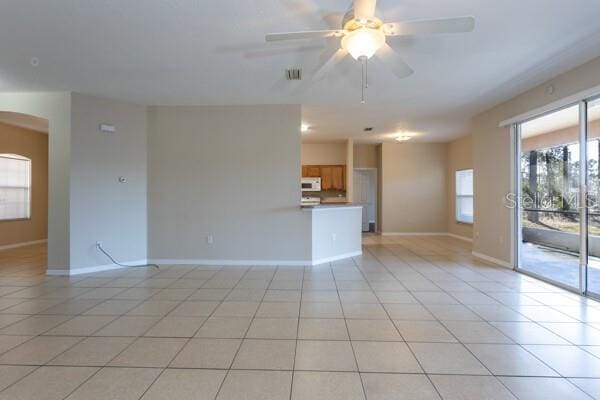 tiled spare room with ceiling fan