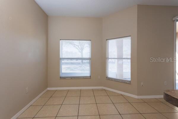 empty room with plenty of natural light and light tile patterned floors