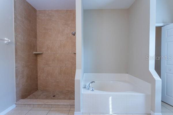 bathroom featuring tile patterned flooring and plus walk in shower