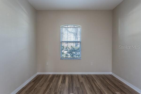 unfurnished room with a wealth of natural light and dark hardwood / wood-style floors