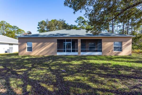 back of house with a lawn and a sunroom