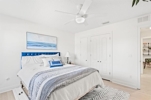 bedroom featuring ceiling fan, light hardwood / wood-style floors, and a closet