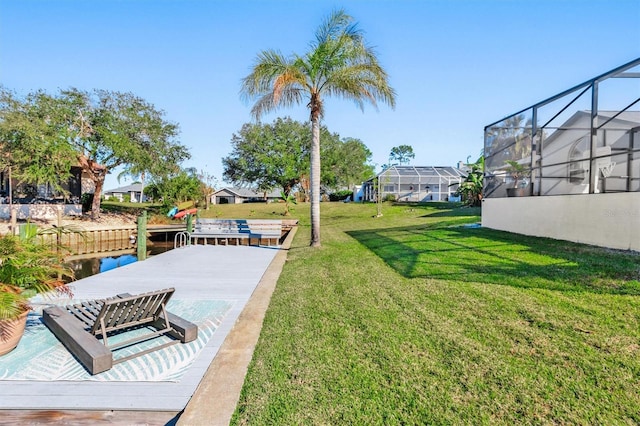 view of yard with a water view and a lanai