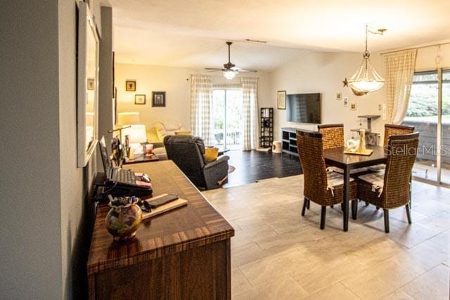 dining room with ceiling fan, vaulted ceiling, and a healthy amount of sunlight