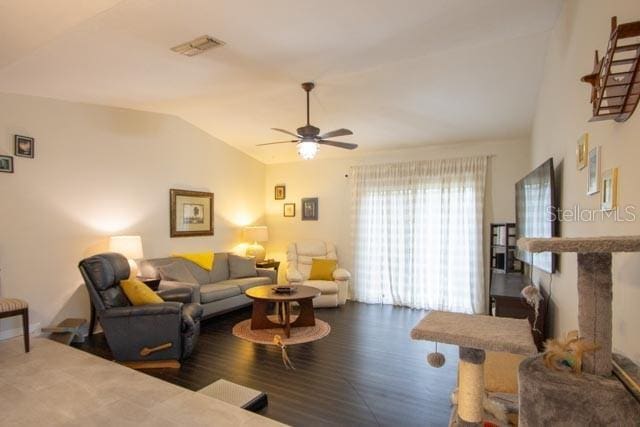 living room featuring ceiling fan, wood-type flooring, and vaulted ceiling