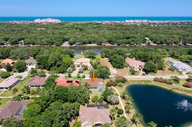 birds eye view of property featuring a water view, a residential view, and a wooded view