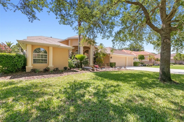 view of front of house featuring an attached garage, driveway, a front lawn, and stucco siding