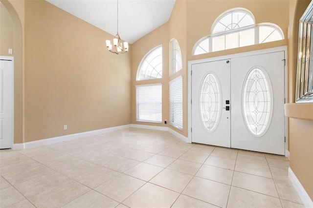 foyer with light tile patterned floors, baseboards, arched walkways, an inviting chandelier, and high vaulted ceiling