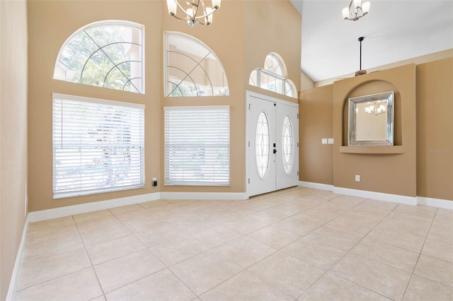 foyer featuring a chandelier, a wealth of natural light, a high ceiling, and light tile patterned floors