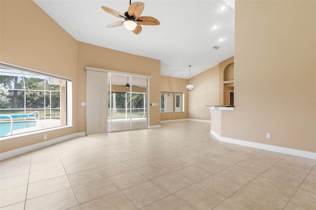 empty room with light tile patterned floors, high vaulted ceiling, recessed lighting, a ceiling fan, and baseboards