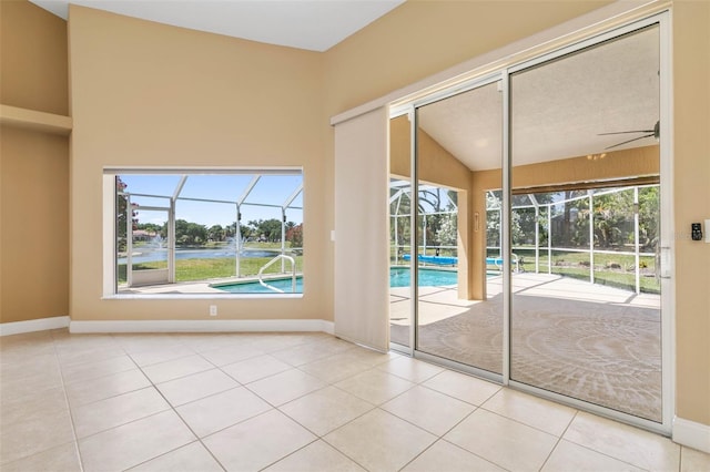 doorway to outside featuring tile patterned flooring, a sunroom, and baseboards